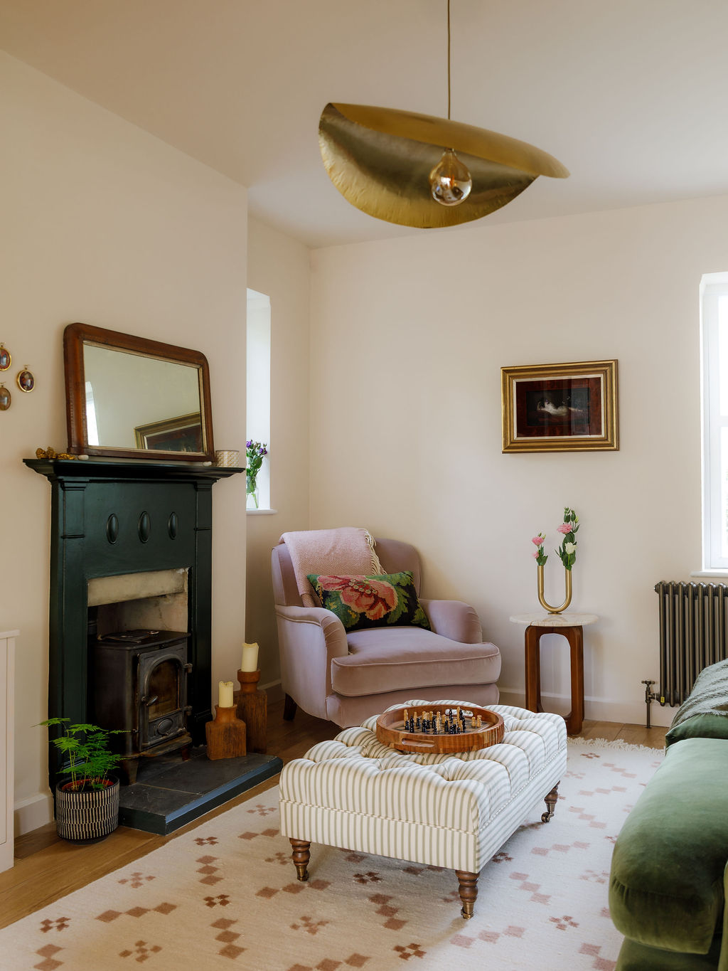 Arts & Crafts living room with original fireplace, sculptural lighting and colourful furniture